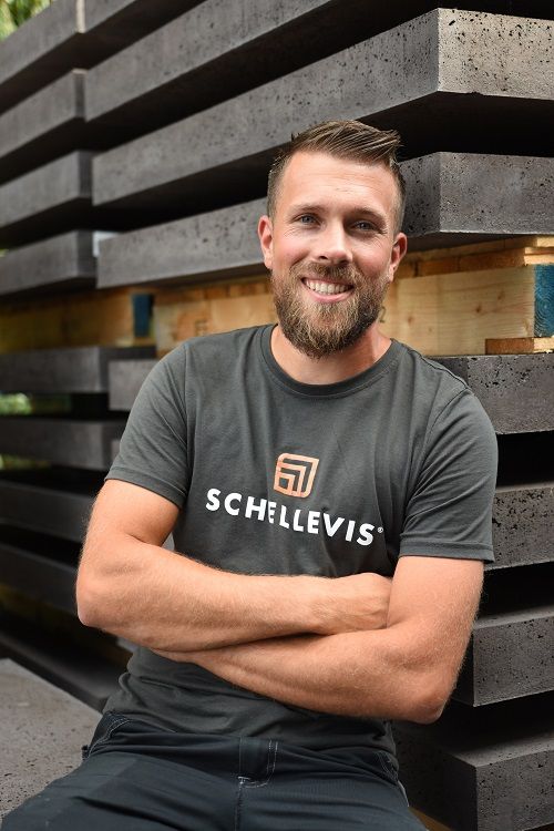 Luke de Ruijter leunt tegen een voorraad tegels. Luke de Ruijter leunt tegen een voorraad tegels.