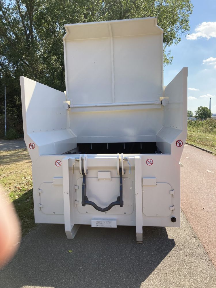 De geopende klep van de perscontainer De geopende klep van de perscontainer