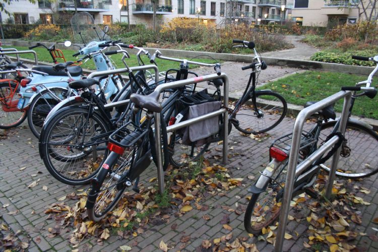 Geparkeerde fietsen nemen een groot deel van de stoep in beslag. Geparkeerde fietsen nemen een groot deel van de stoep in beslag.