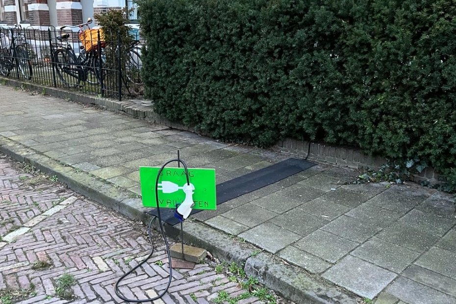 Een provisorisch bordje met het dringende verzoek de plek vrij te houden voor het elektrisch laden van een auto Een provisorisch bordje met het dringende verzoek de plek vrij te houden voor het elektrisch laden van een auto