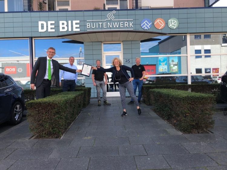Dick Oosthoek, directeur Stichting Groenkeur overhandigt de oorkonde Groenvoorziening aan Joke van der Aar van De Bie Groenwerk.