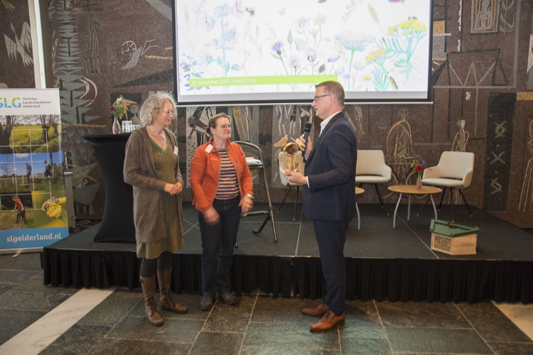 Cecilia Klein en Vivienne van Sante ontvangen de Bermbokaal van gedeputeerde dhr. Zoet.