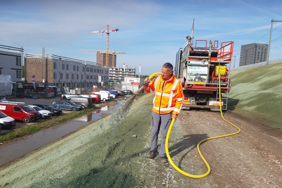 Uitvoerder Patrick Peters van Hydroseeding zaait hydraulisch het steile talud in tussen een nieuwbouwwijk in Lent en het spoor.