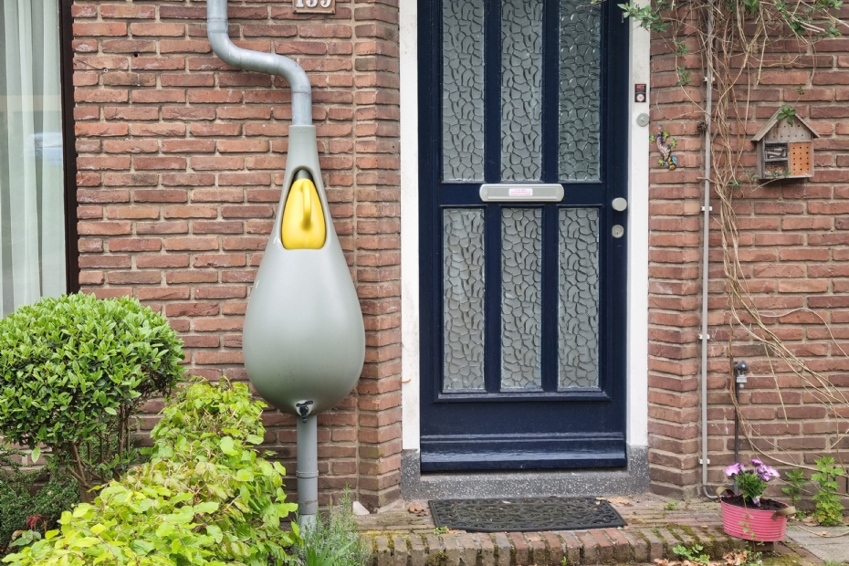Een moderne regenton met geïntegreerde gieter en kraan om een tuinslang op aan te sluiten, beeld ter illustratie