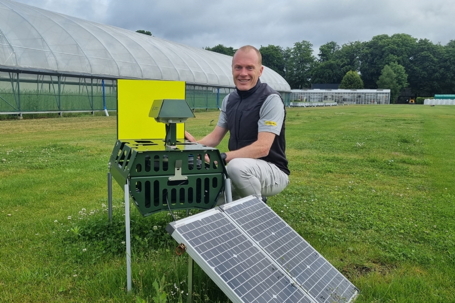 Olaf Bos bij de insectencamera, met duidelijk zichtbaar de gele plaat die insecten aantrekt